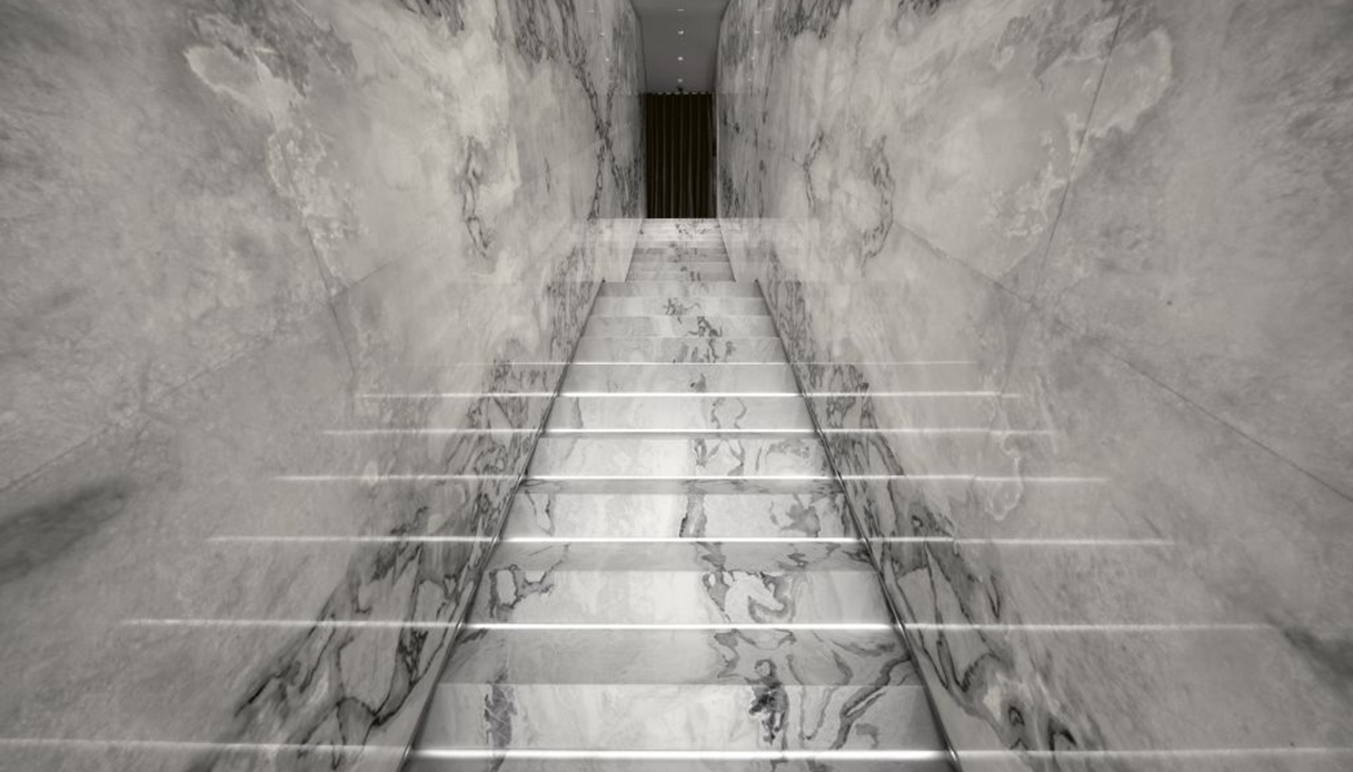 Scala rivestita in marmo Dover White di Antolini con pareti coordinate.