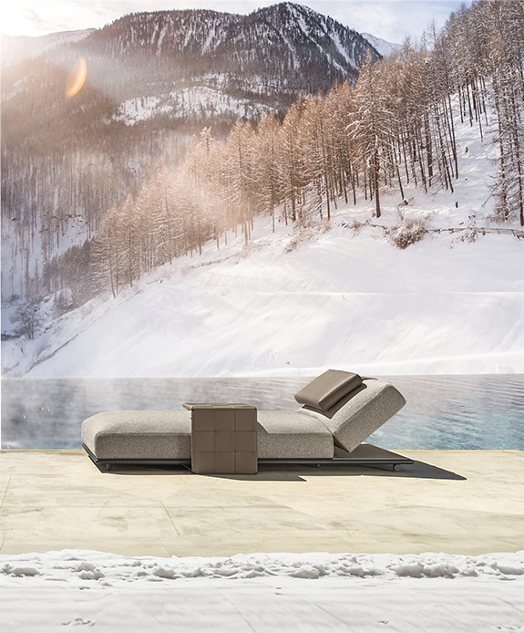 Lettino da esterno vicino a piscina con vista su montagne innevate