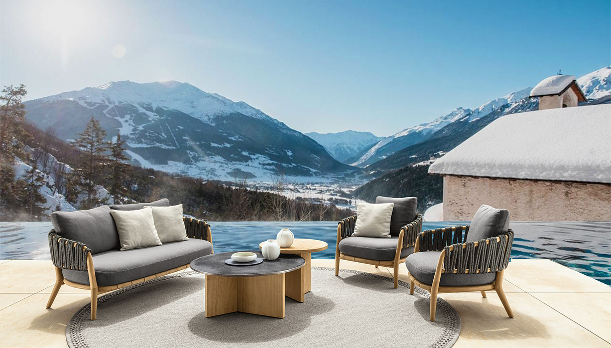 Salotto da esterno con divani intrecciati e vista sulla valle innevata