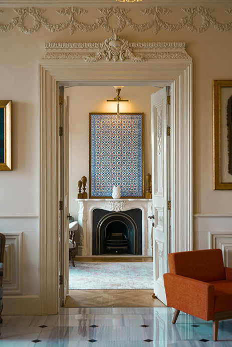 Interno in stile castlecore con camino classico, porte decorate e arredi eleganti.