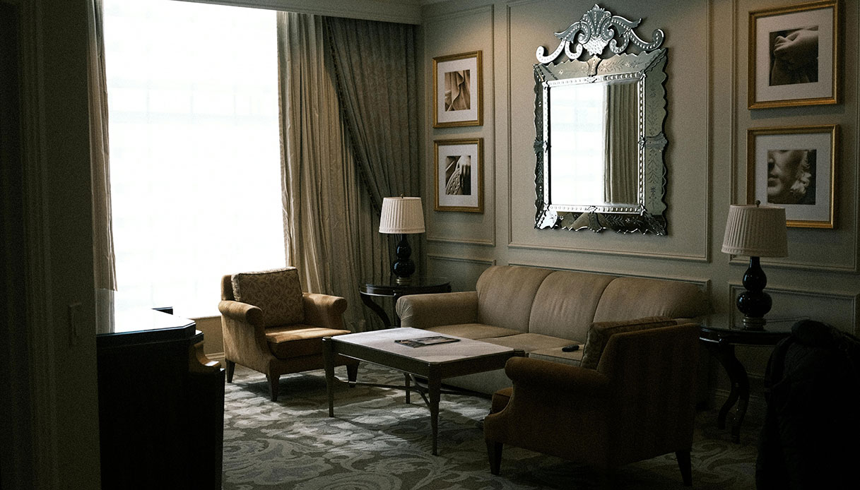 Living room in stile castlecore con divani classici, boiserie alle pareti e illuminazione soffusa.