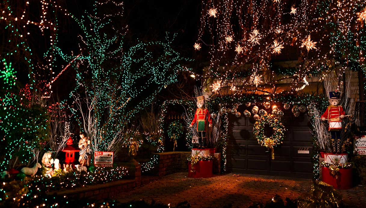 Facciata riccamente decorata con luci natalizie, figure giganti e installazioni luminose