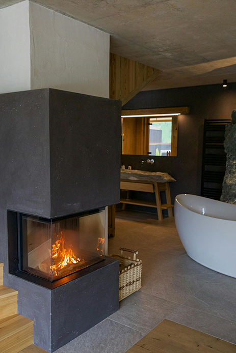 Camino moderno a vista in un bagno con vasca freestanding