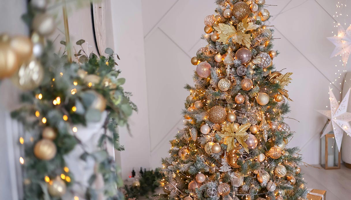 Albero di Natale decorato con palline dorate e luci calde.