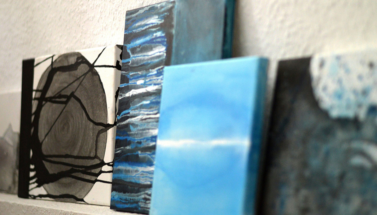 Opere d’arte contemporanea appoggiate su una mensola contro la parete.