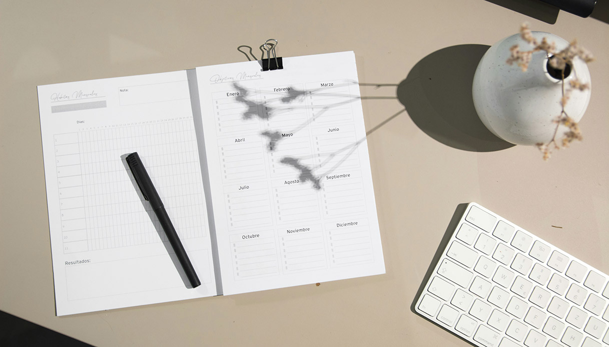 Agenda aperta su una scrivania luminosa con penna e tastiera