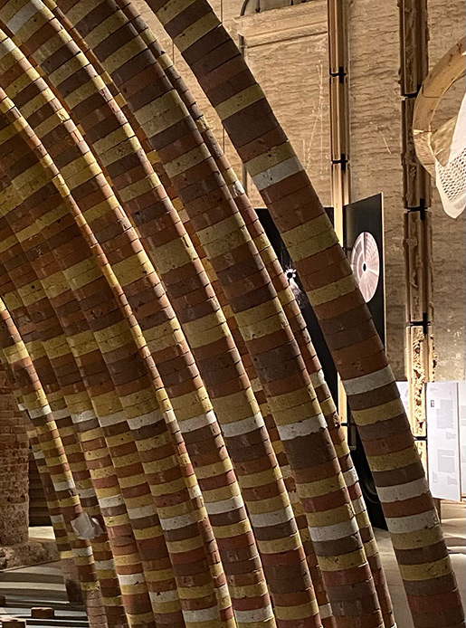 Struttura curva realizzata con materiali bio in un contesto espositivo