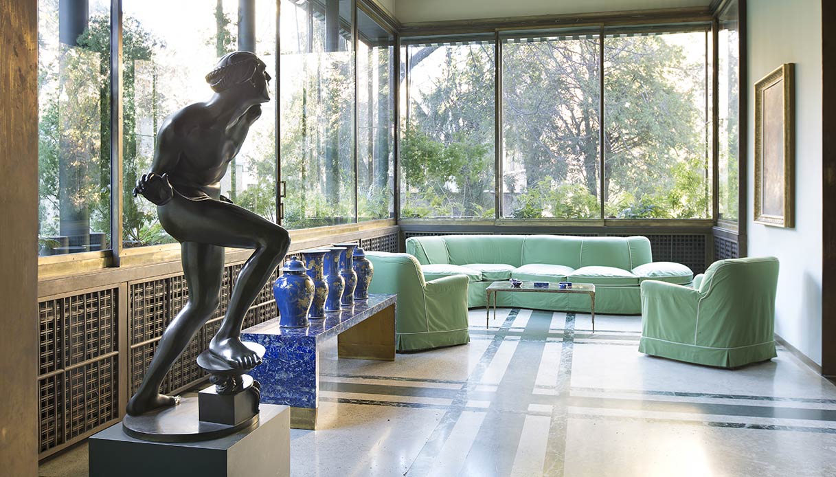 Veranda di Villa Necchi Campiglio con arredi verdi e vetrate