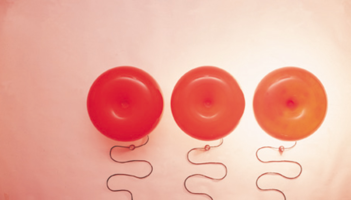 Tre lampade Nesso in diverse tonalit&agrave; aranciate con cavo visibile su sfondo chiaro