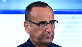 Sanremo 2026, la quarta conferenza stampa. Carlo Conti scorta Irina Shayk: “Non è carino farla aspettare”