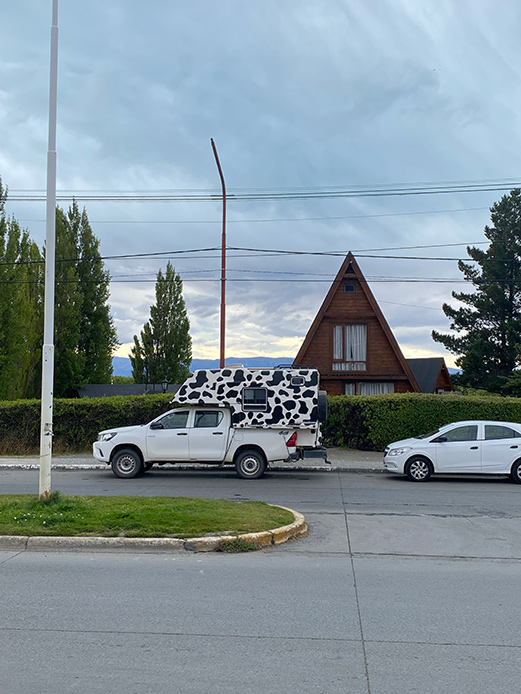 Casa patagonica in legno con tetto triangolare ripido e struttura compatta immersa nel paesaggio urbano australe