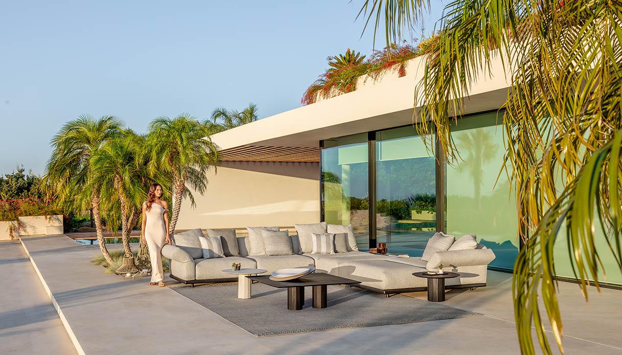 Composizione modulare della collezione Elton Talenti in un patio moderno con ampie vetrate e palme