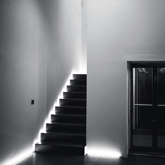 Scala moderna con illuminazione LED integrata lungo i gradini e pareti bianche