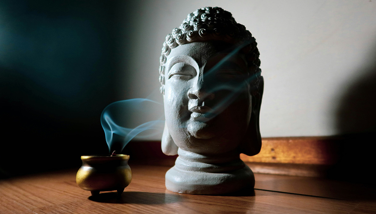 Incenso acceso accanto a una scultura, esempio di design olfattivo per il benessere in casa.