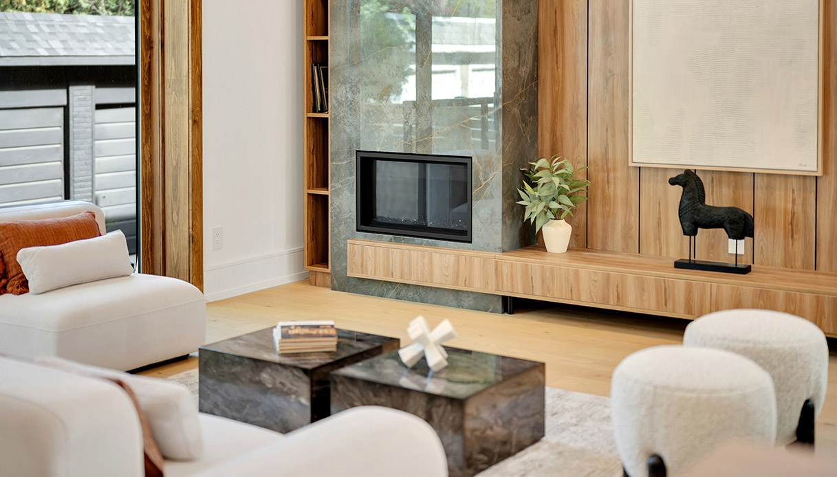 Pouf imbottiti chiari in un salotto moderno con camino e arredi in legno, esempio di living contemporaneo.