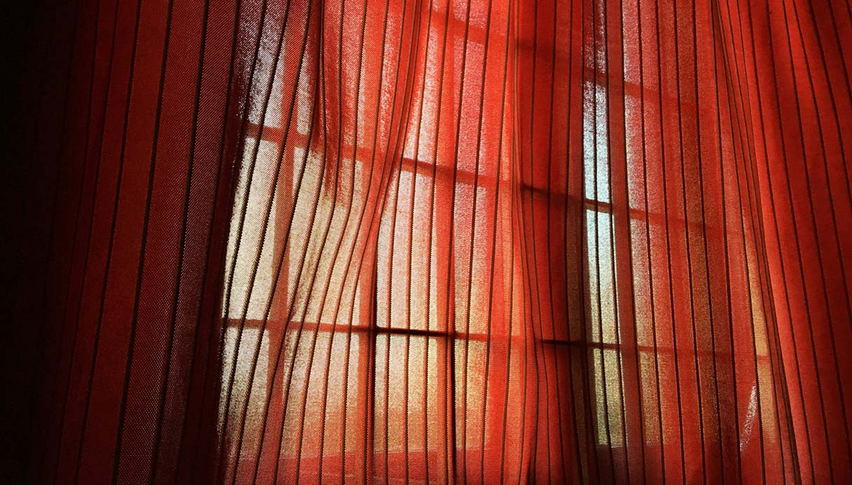 Tende termiche in tessuto pesante davanti a una finestra per limitare la dispersione termica.