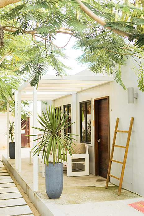 Veranda con piante e materiali naturali, esempio di ristrutturazione esterni attenta alla biodiversità.