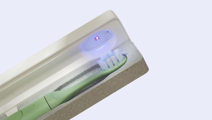 Dettaglio testina spazzolino SURI in custodia con luce UV-C per disinfezione.