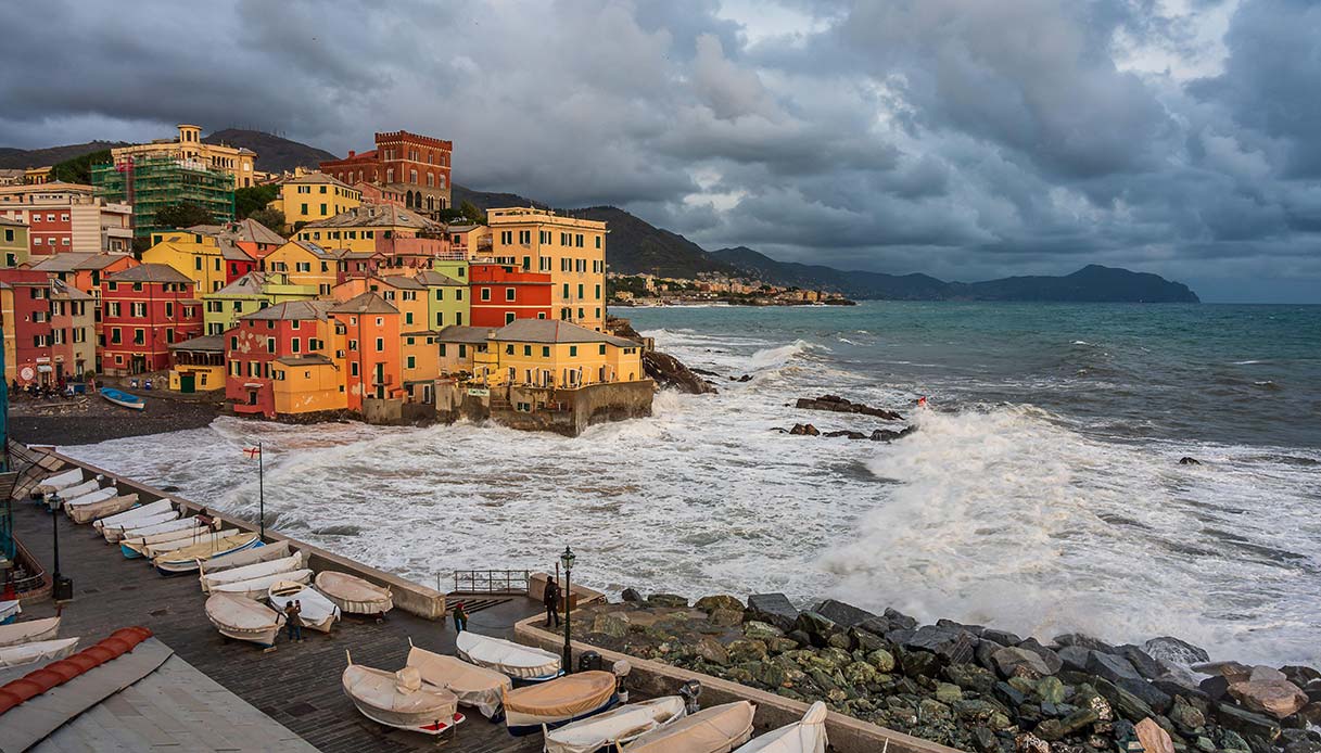 Boccadasse con mare agitato e onde che si infrangono sulle case