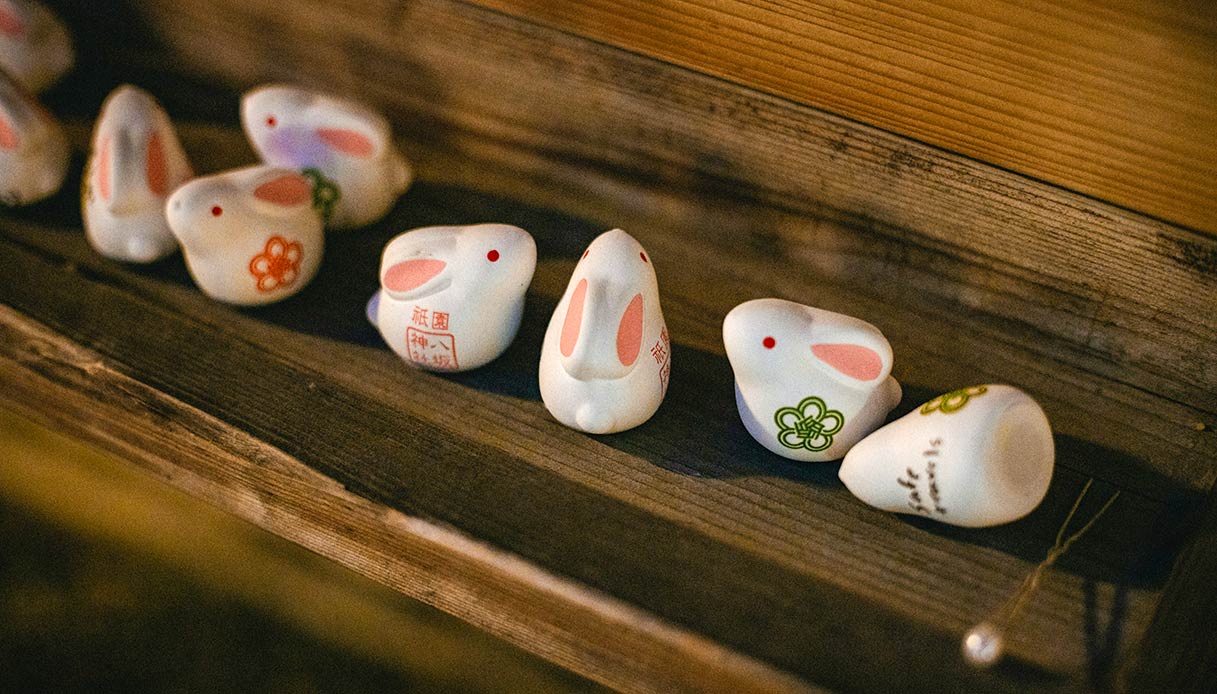 decorazioni pasquali artigianali con conigli in ceramica su superficie in legno