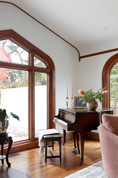Angolo soggiorno con pianoforte vicino a finestra ad arco