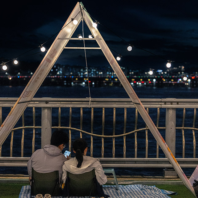 luci festoon appese in terrazzo con vista città di notte atmosfera picnic urbano