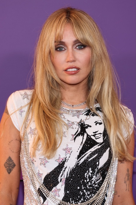 Miley Cyrus alla premi&egrave;re di Hannah Montana anniversary a Los Angeles con abito silver e T-shirt grafica