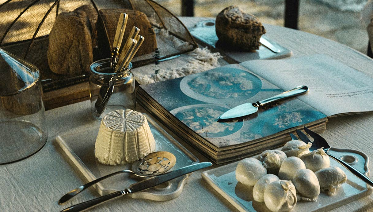 tavola pasqua con formaggi artigianali utensili e materiali naturali in stile slow