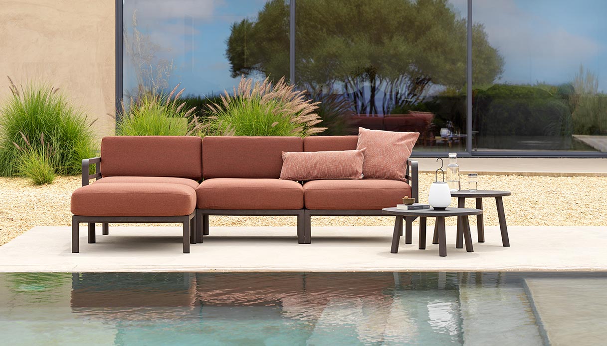 Divano outdoor Nardi MAXIMO con tavolini rotondi 60 e 70 su terrazza con piscina