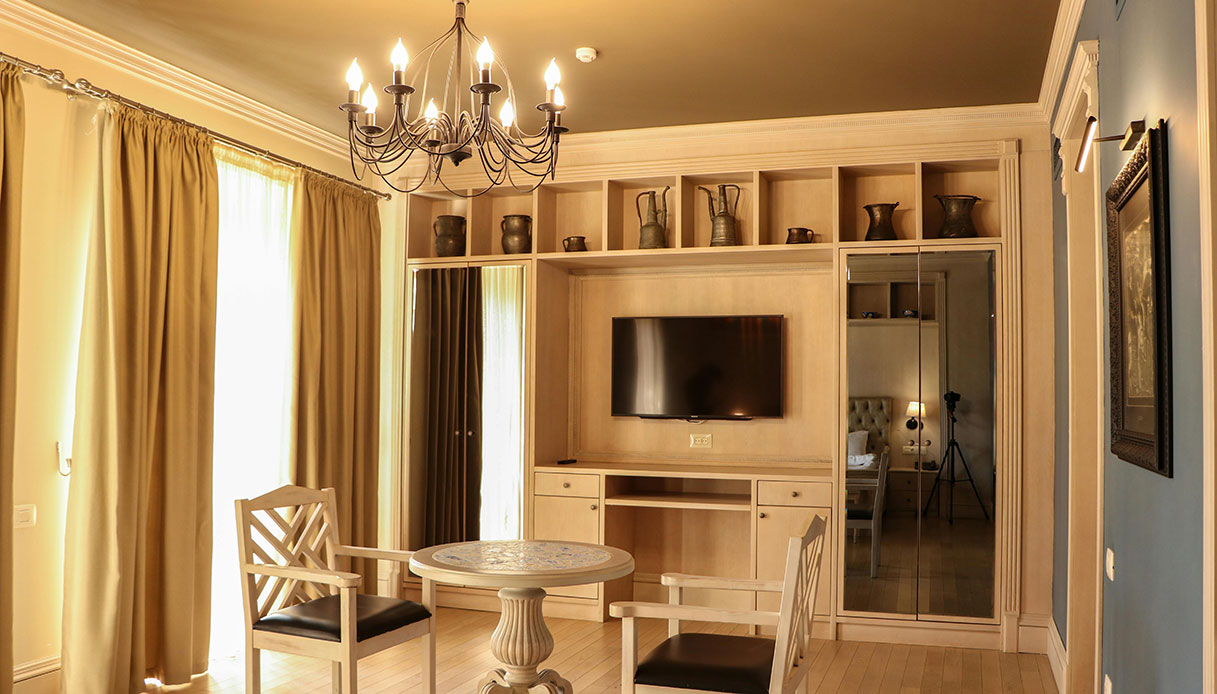 Soggiorno con parete attrezzata e specchio che aumenta la luminosit&agrave;