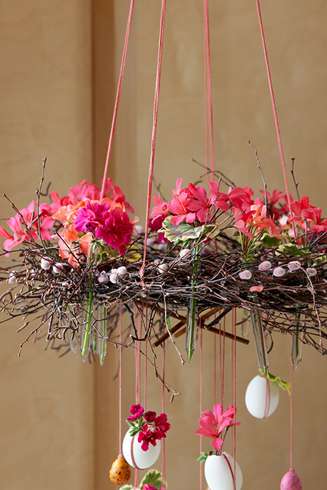 decorazione pasquale con rami intrecciati fiori e uova sospese in stile slow design