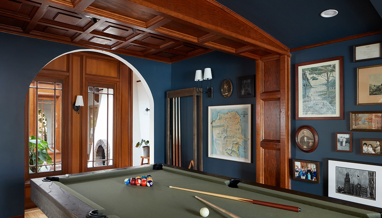 Sala biliardo con pareti blu scuro e tavolo da gioco