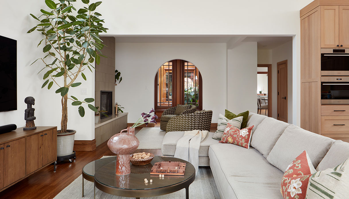 Soggiorno con divano e apertura ad arco verso altre stanze