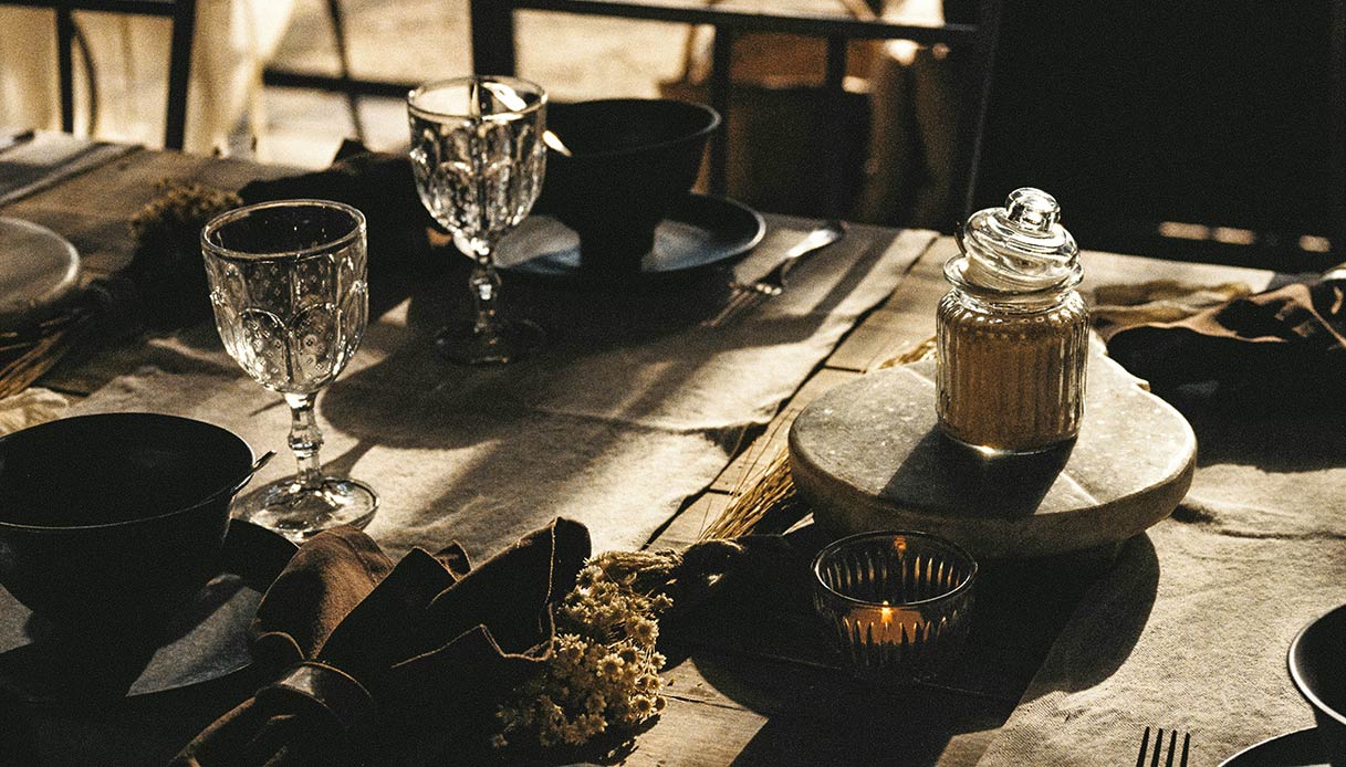 tavola pasqua slow design con lino naturale bicchieri in vetro e stoviglie artigianali