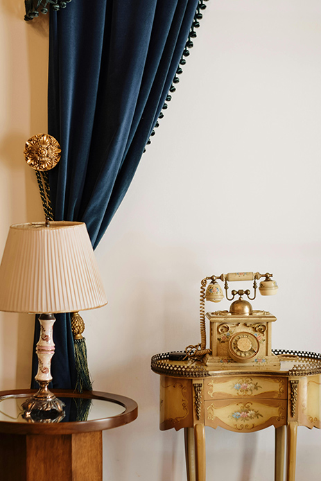 dettaglio tenda in velluto blu e arredi classici in stile parigino