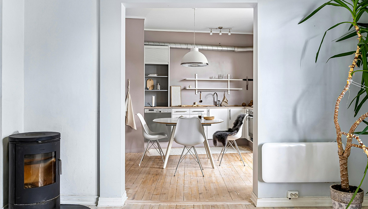 cucina open space con tavolo rotondo, colori beige e arredi minimal caldi