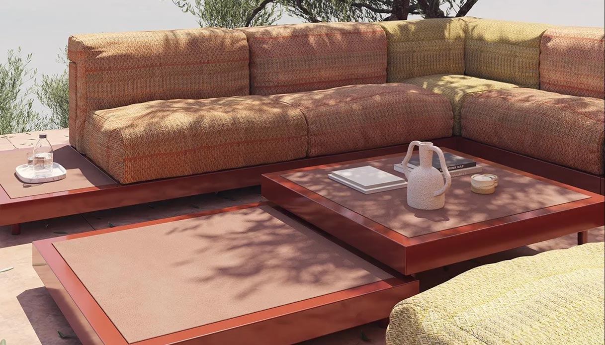 Divano modulare outdoor Boira di Musola con tavolini bassi in metallo rosso mattone e cuscini in tessuto arancio e verde
