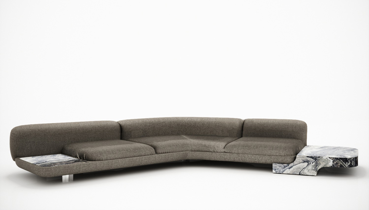 Divano angolare modulare Sebastien Diviana in tessuto grigio con inserti laterali in marmo bianco e nero venato, su fondo bianco neutro