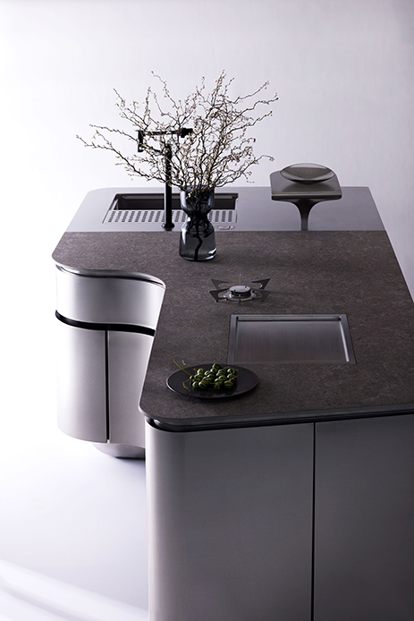 Vista dall'alto della cucina Meisdel Anima01 con piano in gres scuro, lavello rettangolare incassato, piano cottura a induzione e modulo cilindrico bianco laterale