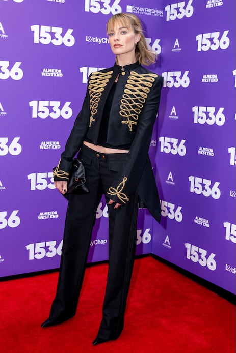 Margot Robbie alla premi&egrave;re di 1536 a Londra con giacca militare McQueen nera e dettagli oro