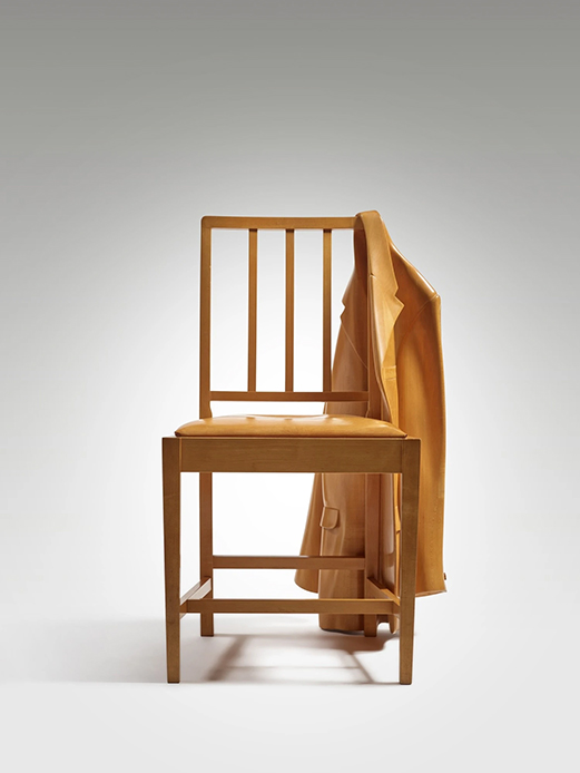 Vista frontale di Coat on a Chair di Wendell Castle: sedia in acero con giacca apparentemente appoggiata allo schienale, tutto in un unico blocco intagliato