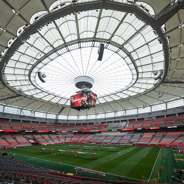 Interno del BC Place di Vancouver con il tetto retrattile aperto al centro, il maxischermo sospeso e il manto erboso in fase di preparazione