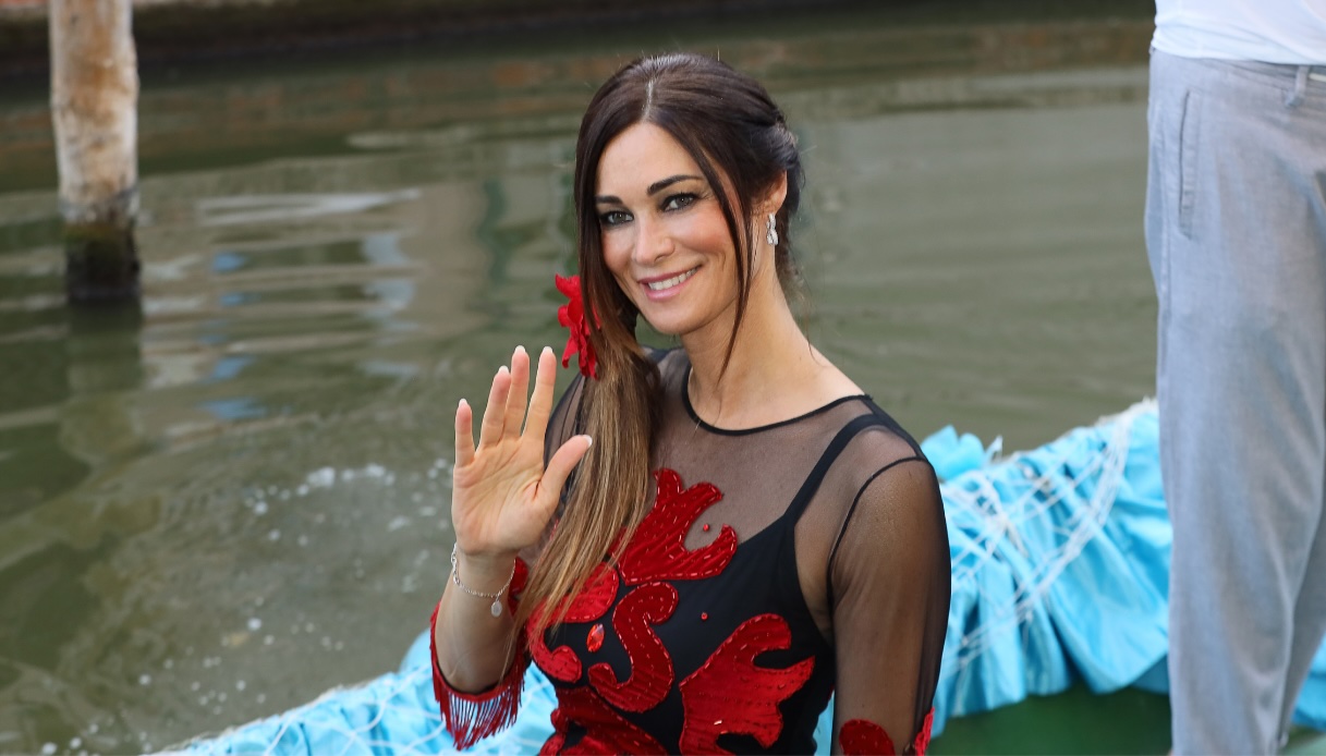 Manuela Arcuri al Carnevale sull&rsquo;acqua di Comacchio con top nero sheer e ricami rossi a bordo di una barca