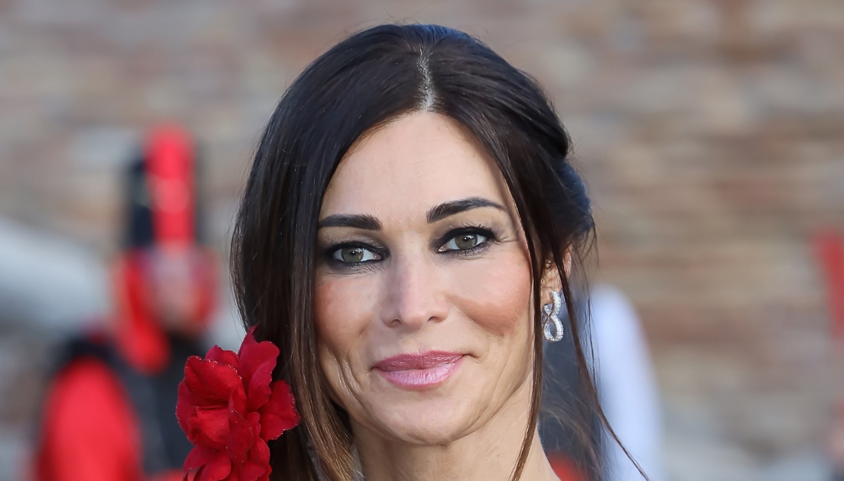 Manuela Arcuri, top sheer e ricami rossi: al Carnevale sull’acqua di Comacchio è pura seduzione