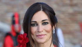 Manuela Arcuri, top sheer e ricami rossi: al Carnevale sull’acqua di Comacchio è pura seduzione