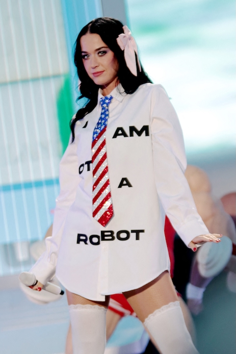 Katy Perry al Blenheim Palace Festival con camicia bianca oversize, cravatta glitterata e calze alte bianche