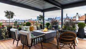 Sedute basse, tavoli curvi e piante in abbondanza. Il balcone raddoppia