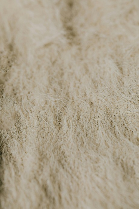 Dettaglio ravvicinato di una texture fibrosa e ruvida color sabbia