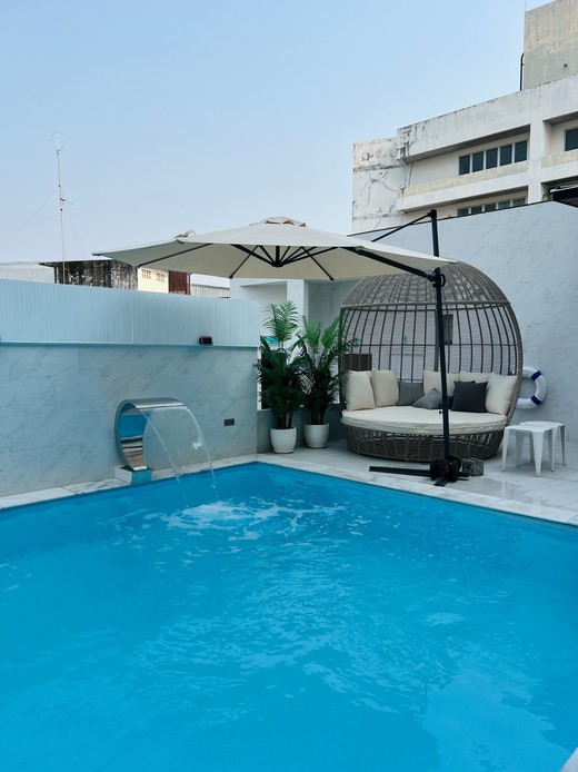 Daybed rotondo in vimini a bordo piscina con ombrellone