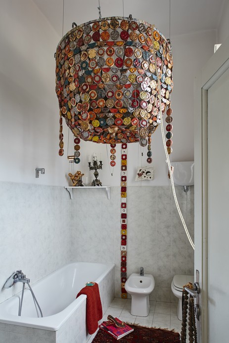 Sala da pranzo con cuore in ceramica appeso sopra il tavolo e madia con specchio